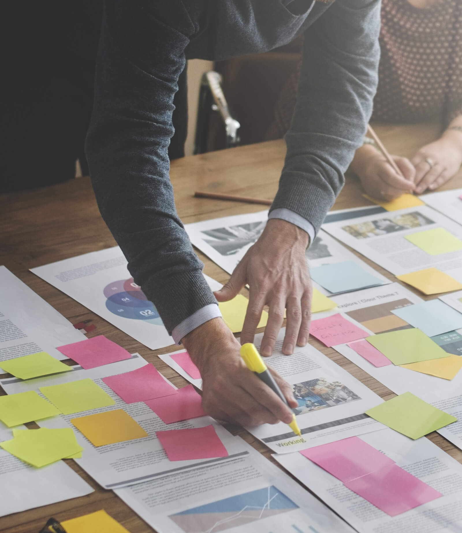 person marking documents with sticky notes